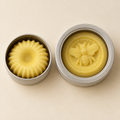 Small flower-shaped and large bee-embossed lotion bars in silver tins